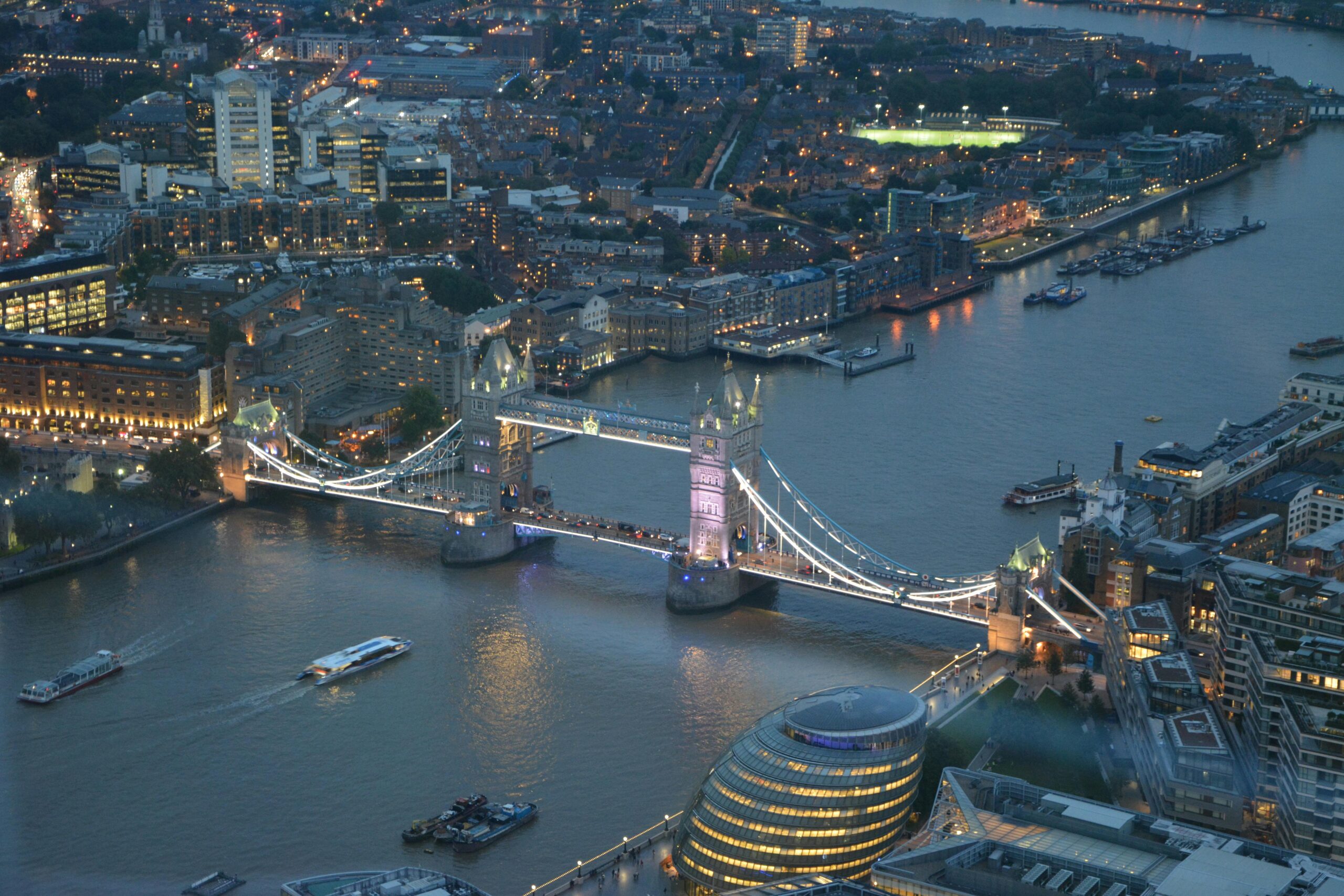 A stunning aerial photograph capturing Londons Tower Bridge illuminated at night over the Thames River