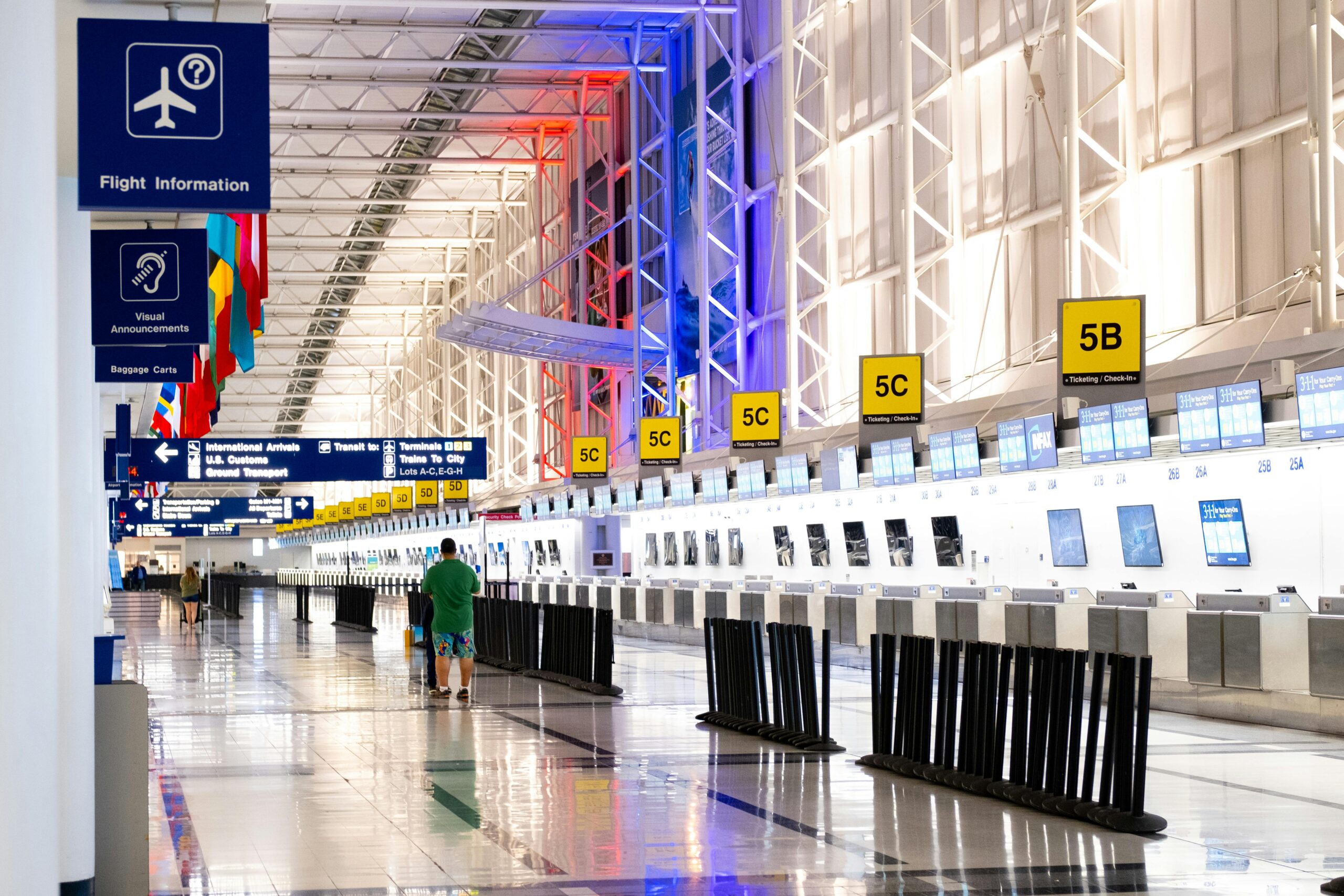 Wide view of Chicago airport terminal showcasing architecture and check in counters Flags and signages add vibrant detail