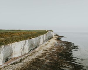 A stunning aerial view of the iconic white cliffs of Dover against a tranquil sea.