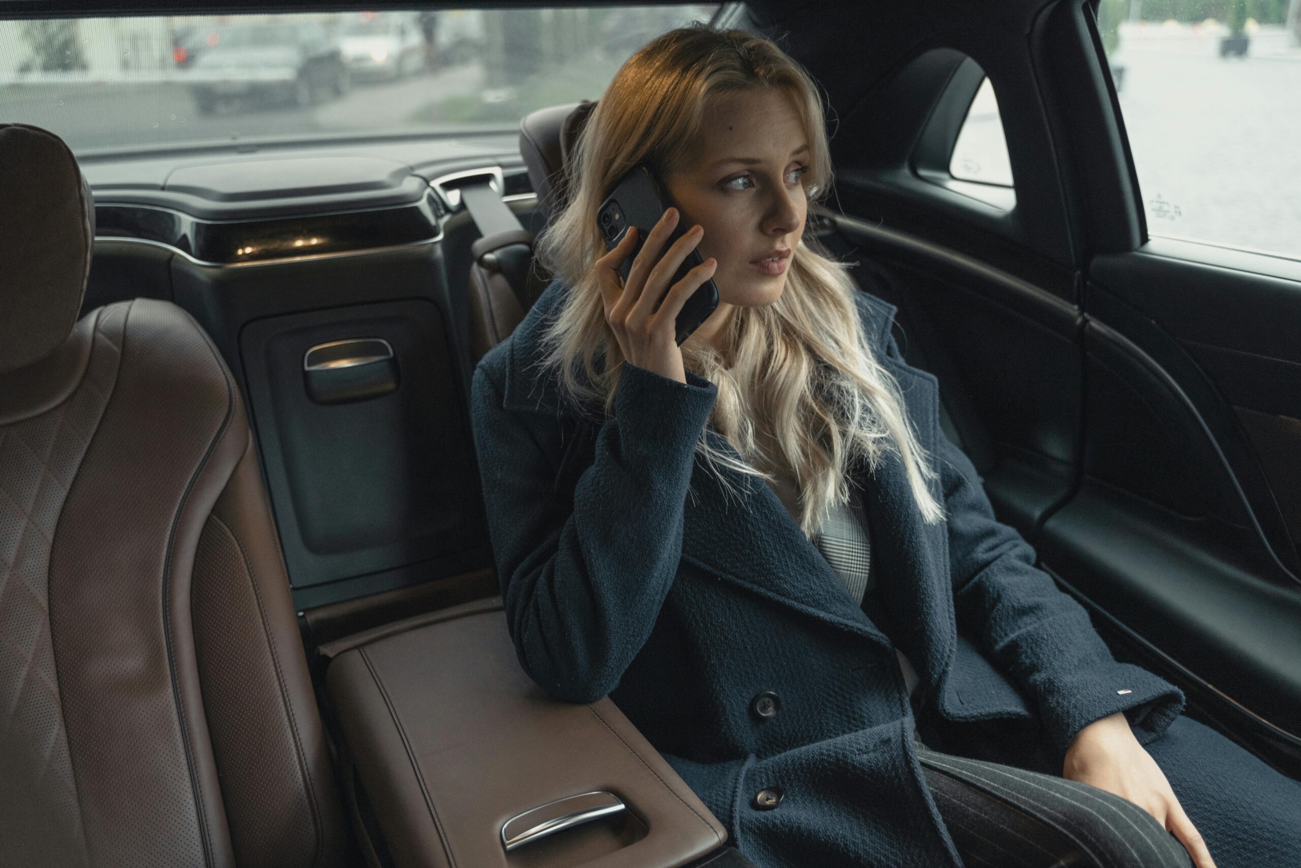 Young businesswoman talking on phone in a luxury car Professional and confident