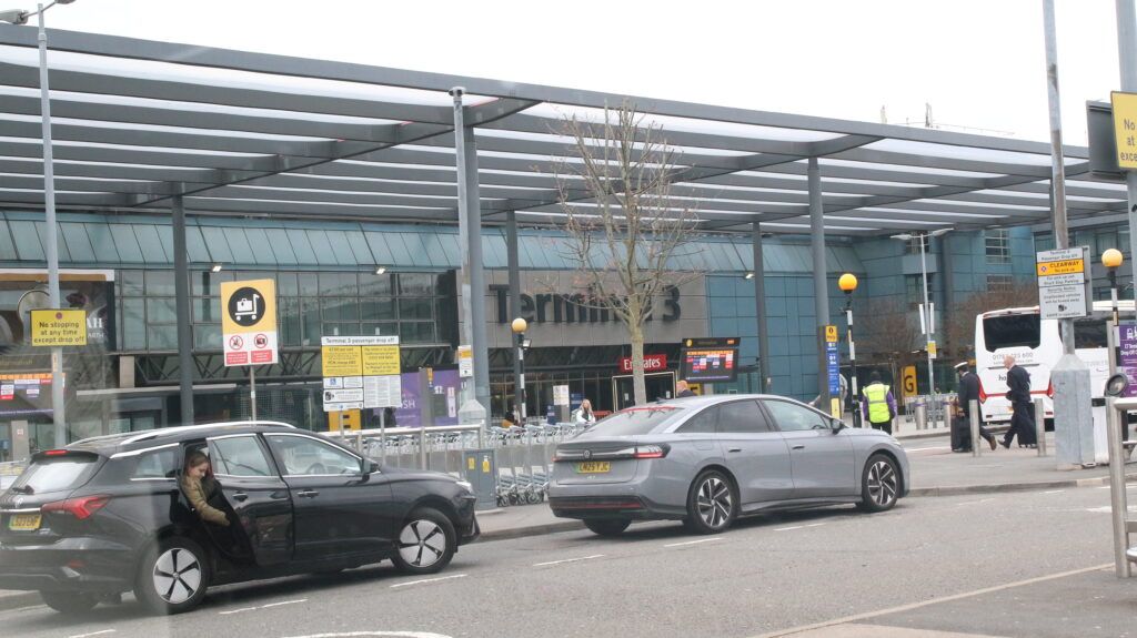 Heathrow Terminal 3 forecourt with cars at the passenger drop off area, showing airport transfer chauffeur service in London.