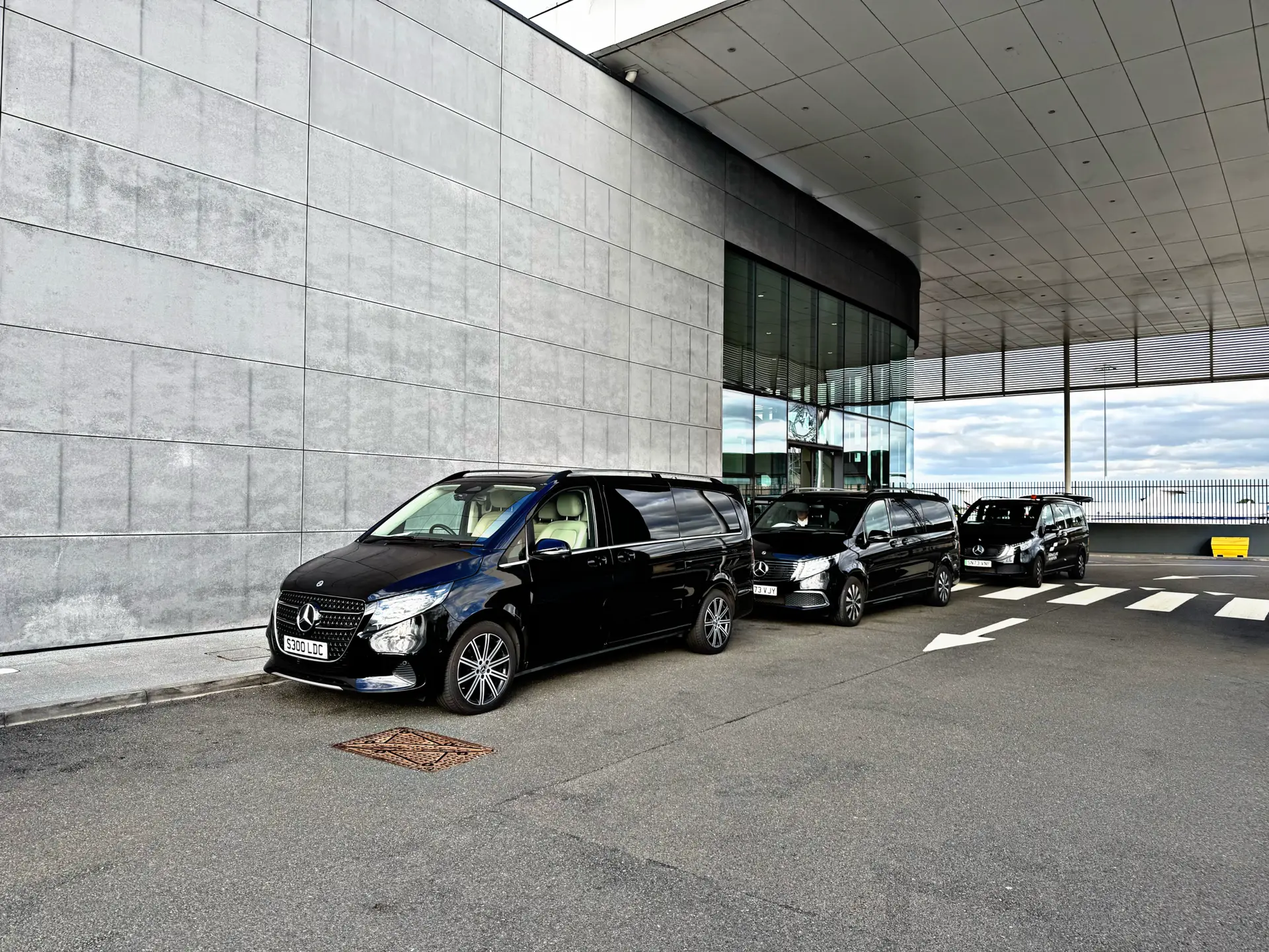 Black Mercedes V-Class chauffeur vehicles waiting outside Signature Aviation at London Luton Airport.
