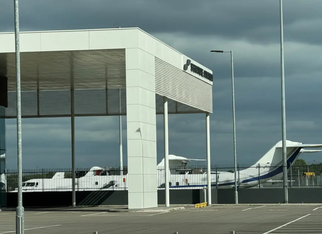 Signature Aviation terminal at London Luton Airport with private jets parked behind the fence.