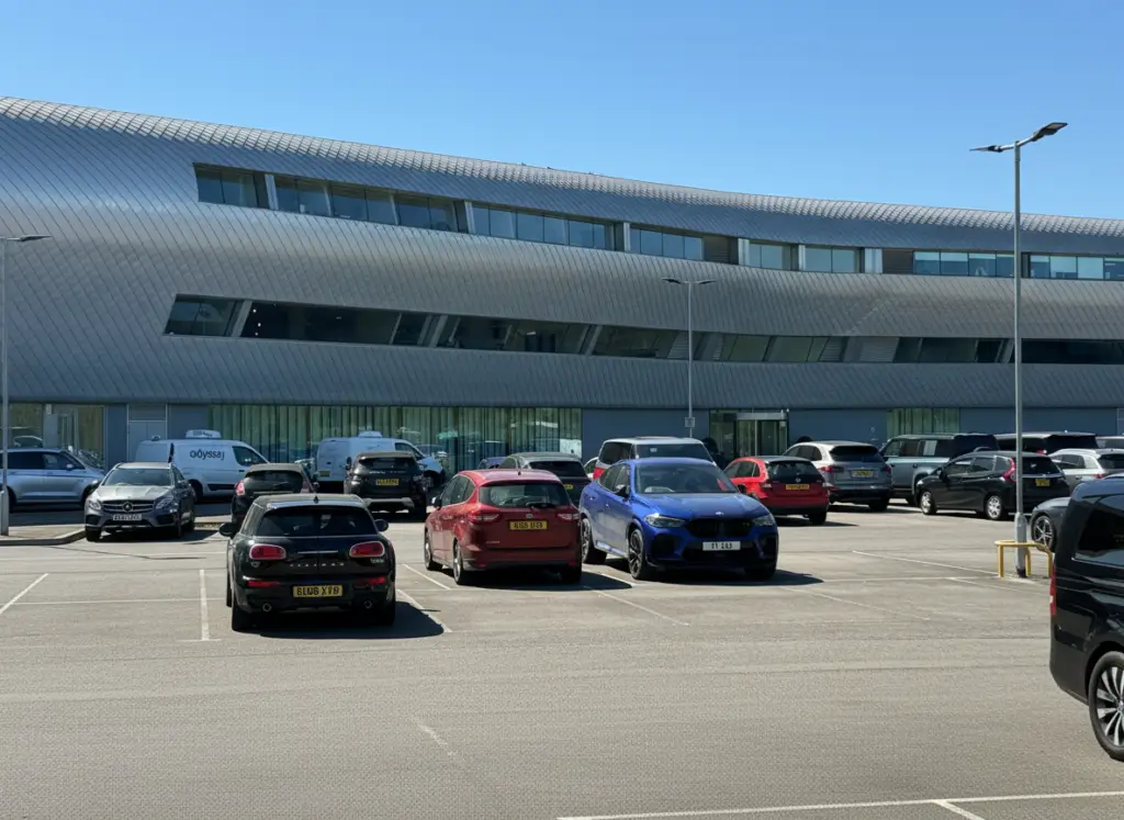 Professional chauffeur beside black Mercedes S-Class in Farnborough